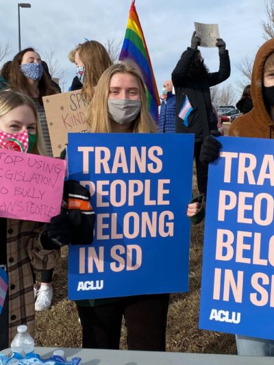 South Dakota Protest Image with people holding "trans people belong in SD" signs