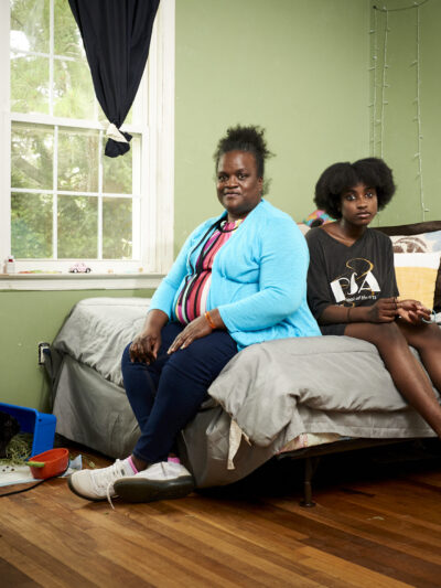 Mother and child sitting on a bed in a bedroom
