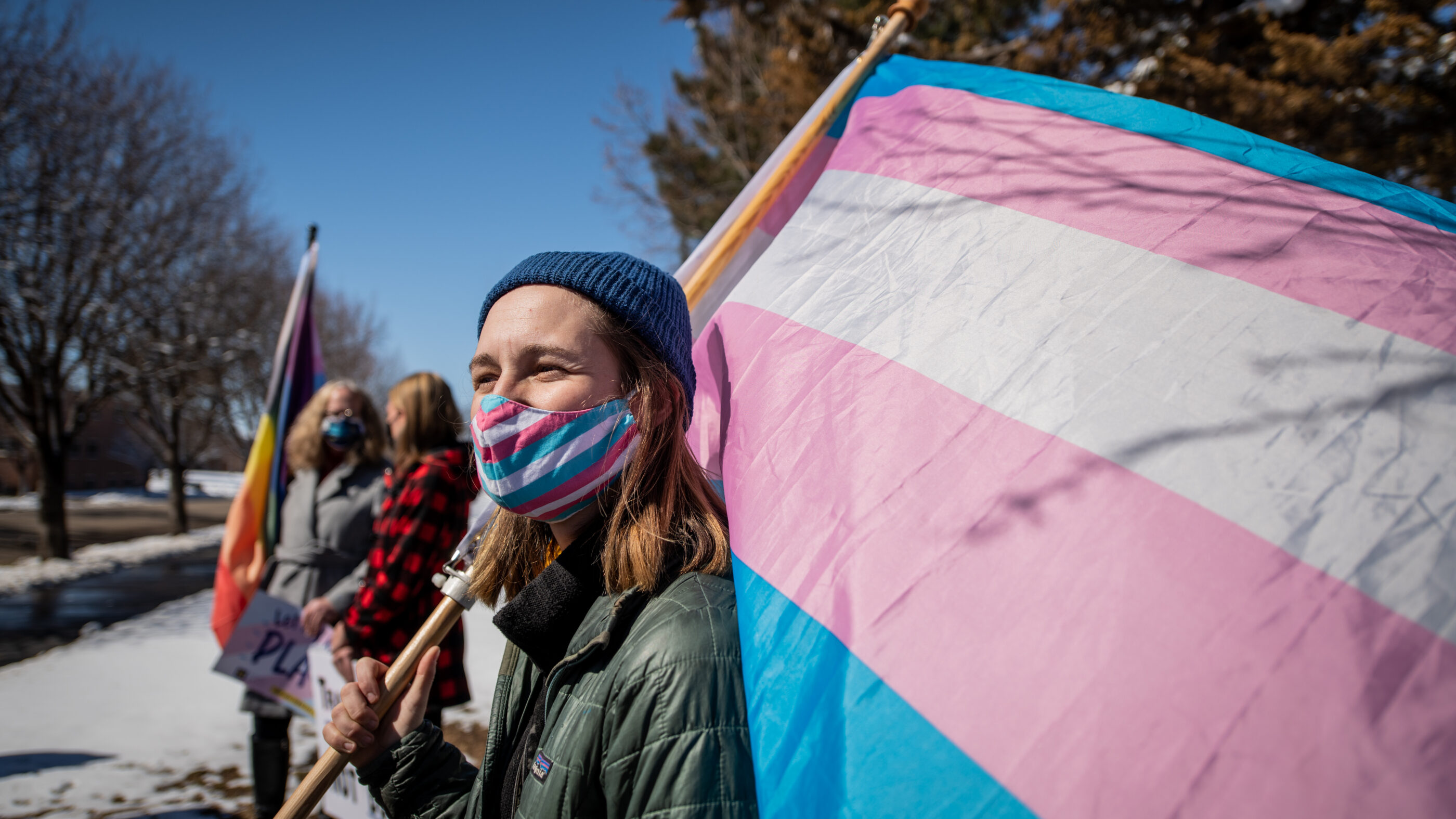 Image of someone holding a trans flag