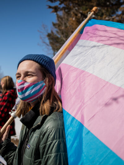 Image of someone holding a trans flag
