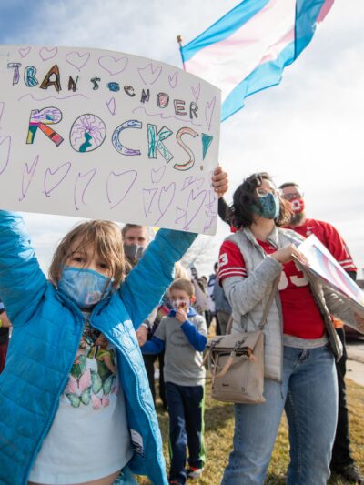 Kid with sign saying Transgender Rocks