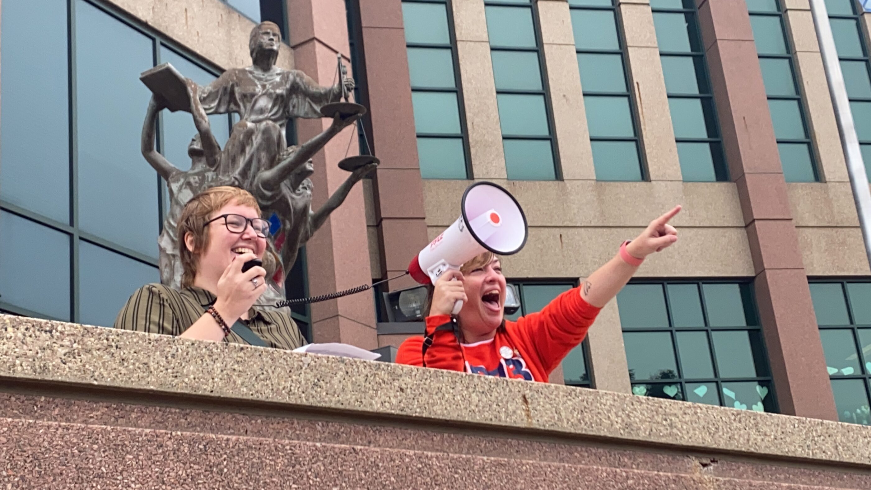 Image of two people speaking at a rally