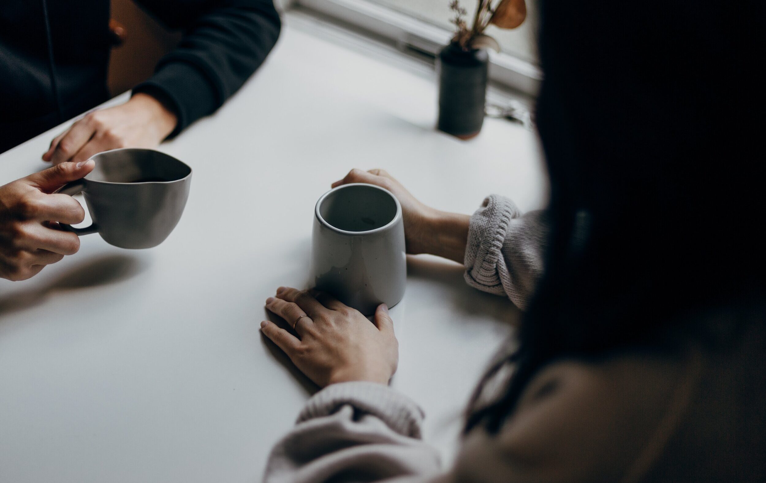 Image of two people at a table having a conversation over coffee