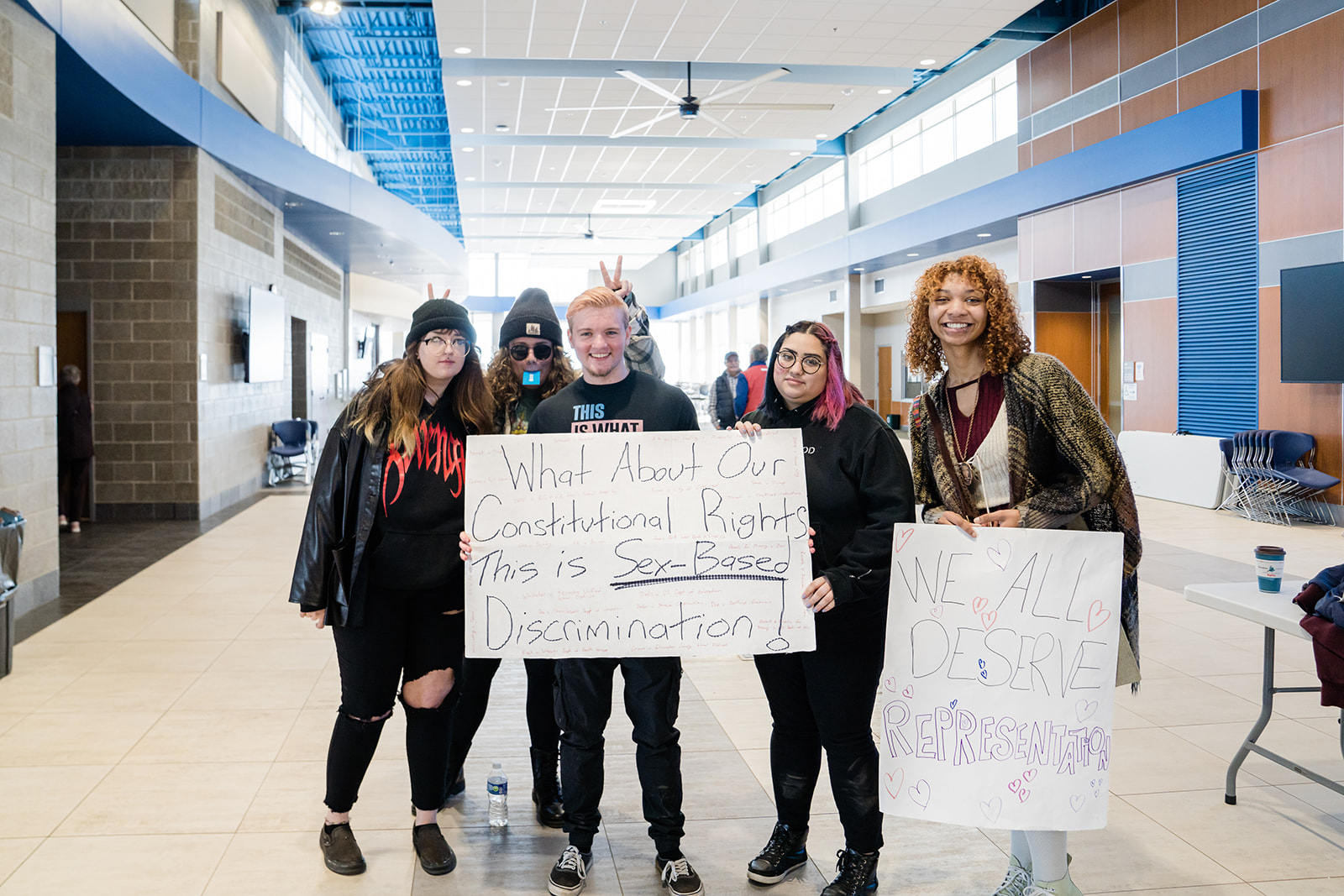 People at a Legislative Coffee holding protest signs