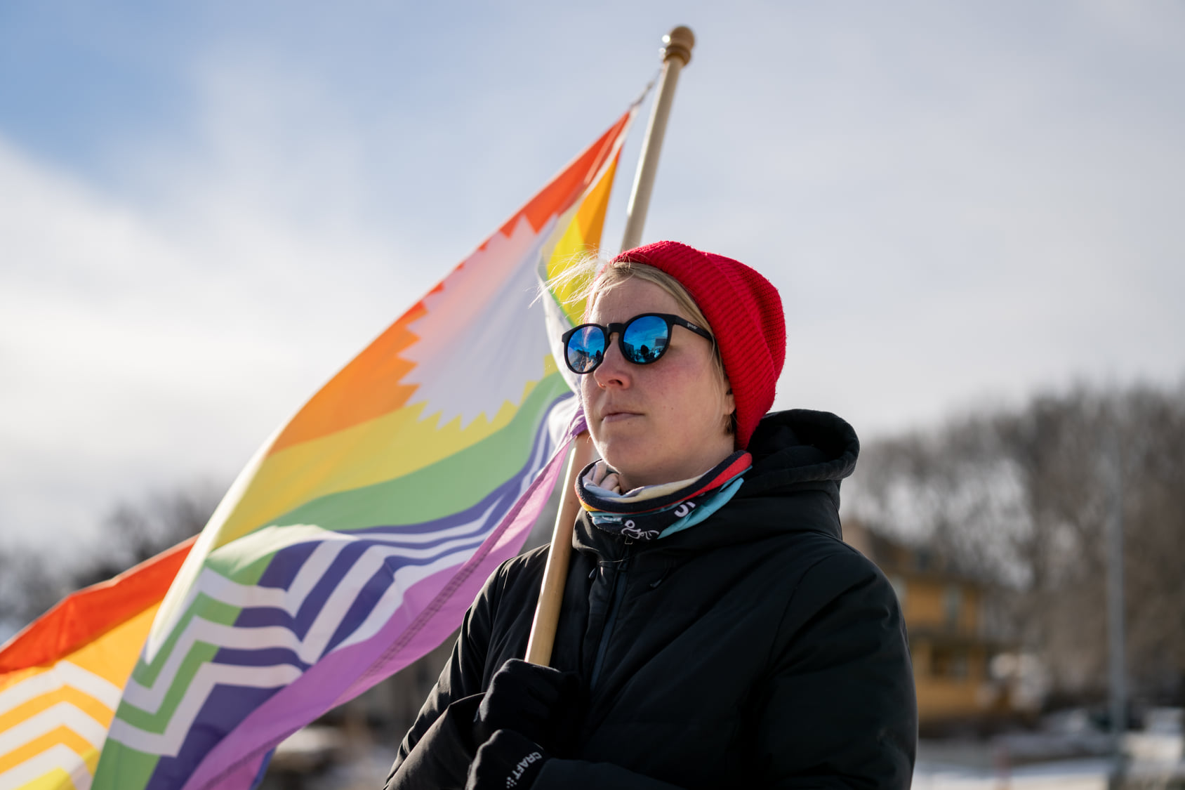 Person holding a pride flag, looking onward.