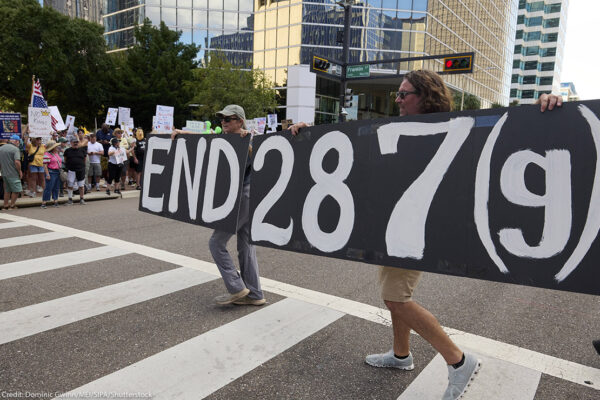 People in Florida carry a sign calling for an end to 287(g).