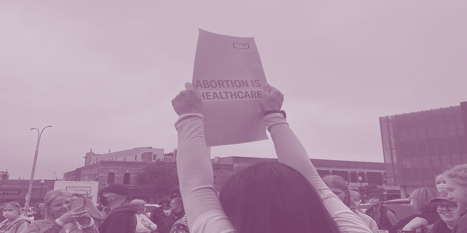 A person holding an "Abortion is healthcare" protest poster 