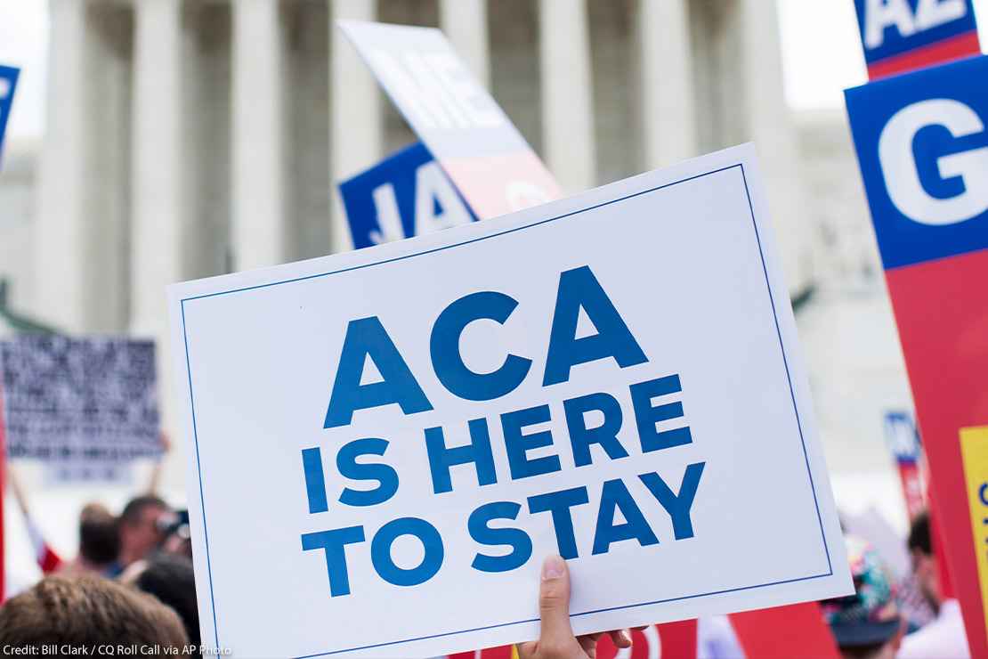 Affordable Care Act Supporter waves sign that reads "ACA is here to stay" outside of the Supreme Court.