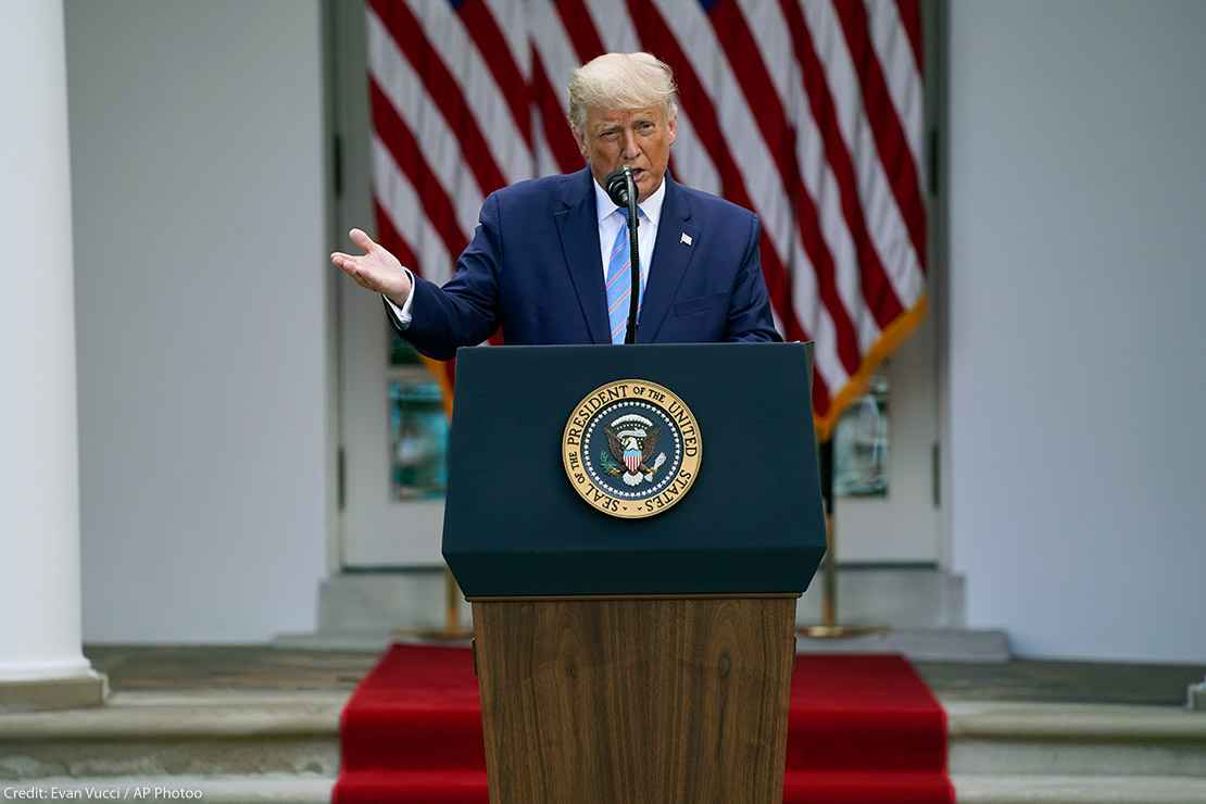 President Donald Trump speaks about podium with presidential seal during an event in the Rose Garden of the White House.