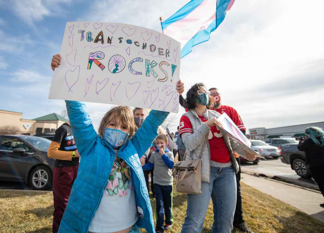 Kid with sign saying Transgender Rocks