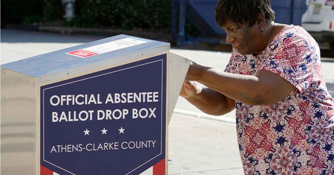 An African-American woman dropping their ballot off during early voting in Athens, Ga.