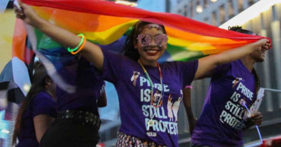 Person wearing a "Pride is still protest" t-shirt