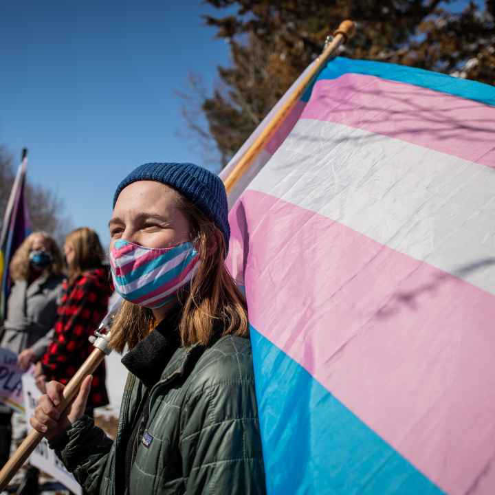 Image of someone holding a trans flag
